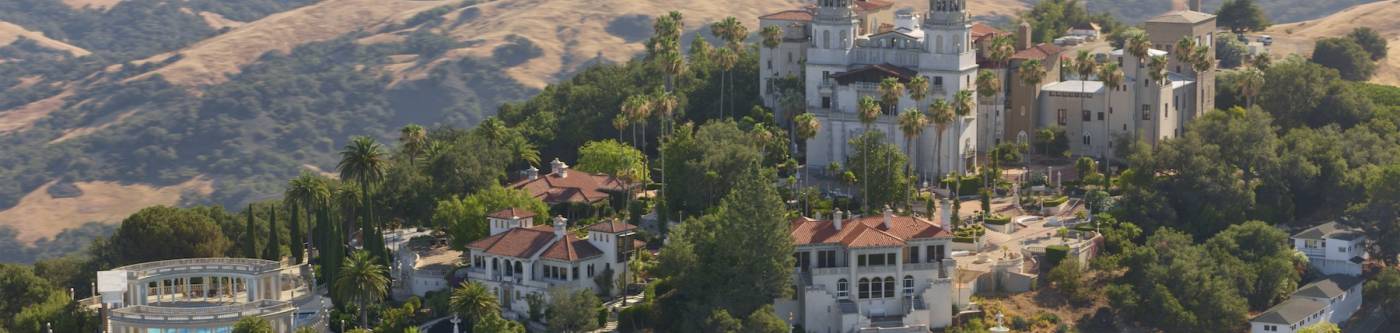 wide view of the grounds of Hearst Castle, the pools and two guest mansions