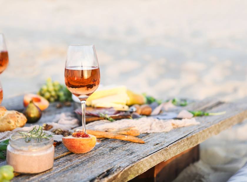 Wine glass and food on beach